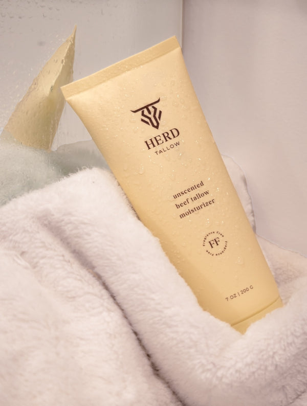 HERD Tallow moisturizer tube on a fluffy white surface